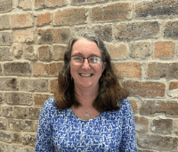 Photo of Elaine Tait standing in front of a wall