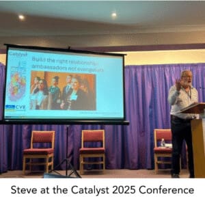 Steve speaking at a lecture with PPT in the background
